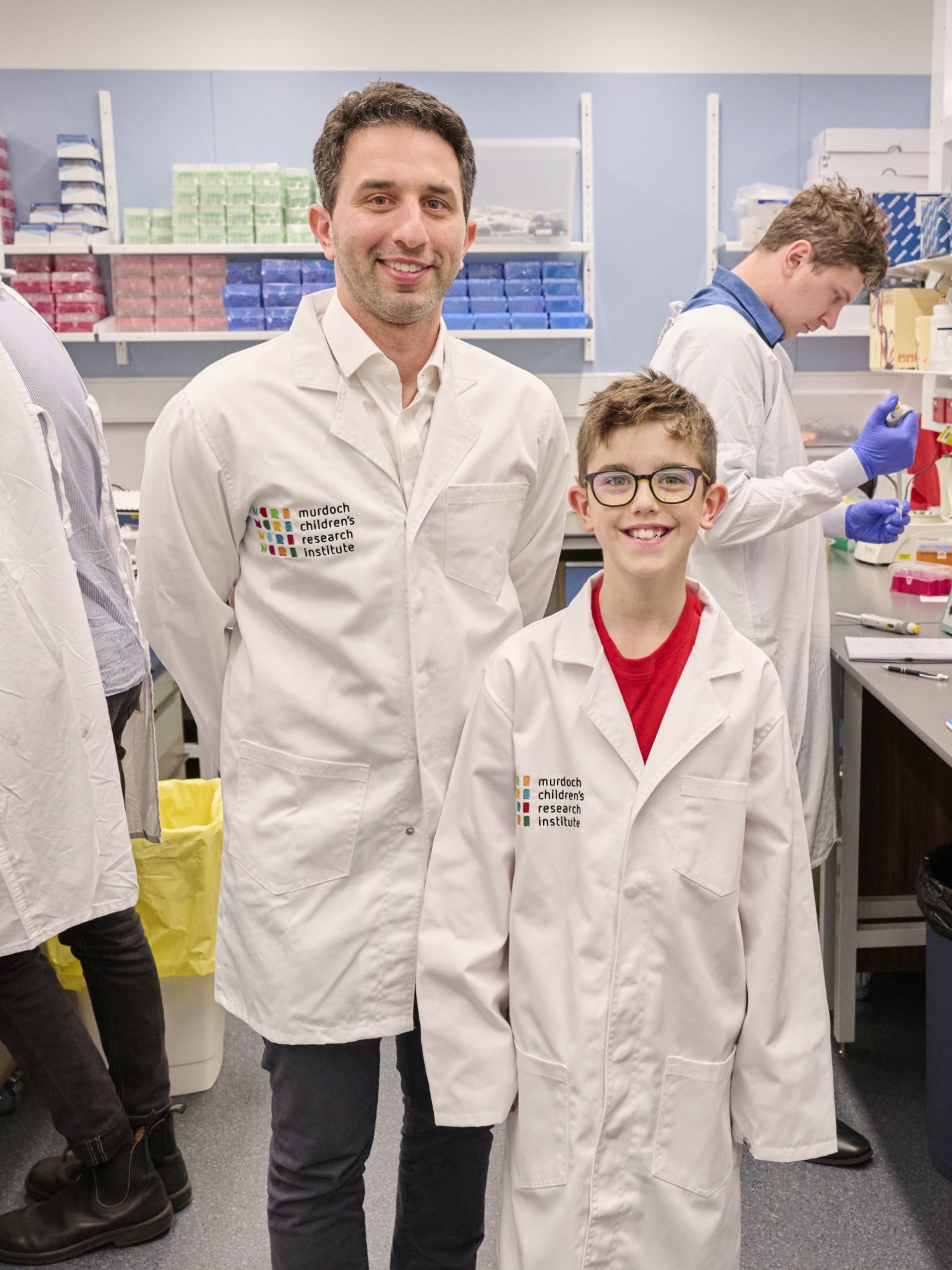 Researcher Enzo Porrello with child in lab